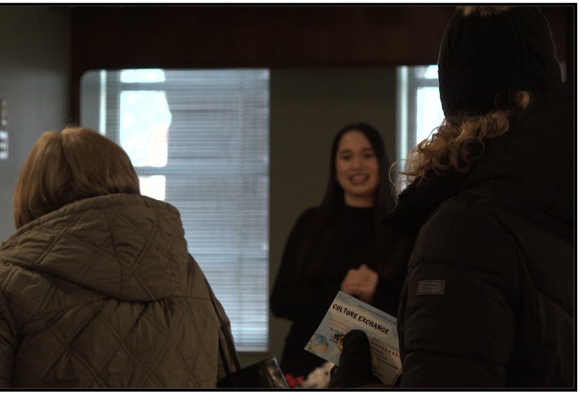 Guests interact with the culture exchange presenter after the event concludes.