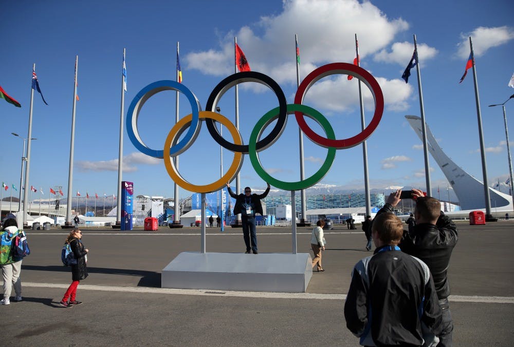 People pose with the Olympic rings inside Olympic Park in Sochi, Russia. Norway is currently in lead for medals at the end of the fifth day of events. MCT PHOTO