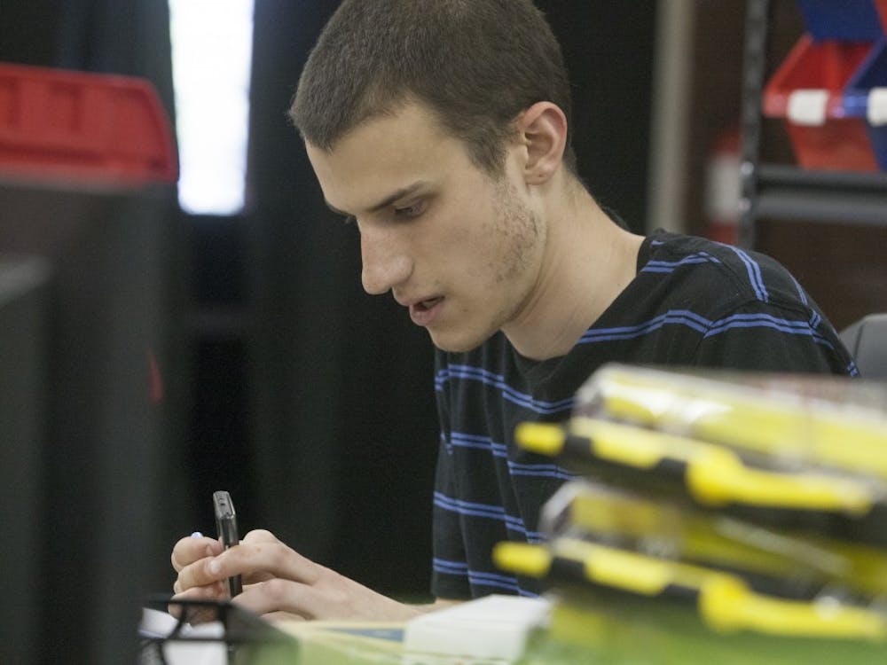 Justin Dunmyer works on a phone at MDtekk in Muncie. Ball State alumnus Dunmyer and student Zachary Marvel created the business. MDtekk currently has a store in Muncie and in Anderson. DN PHOTO JORDAN HUFFER