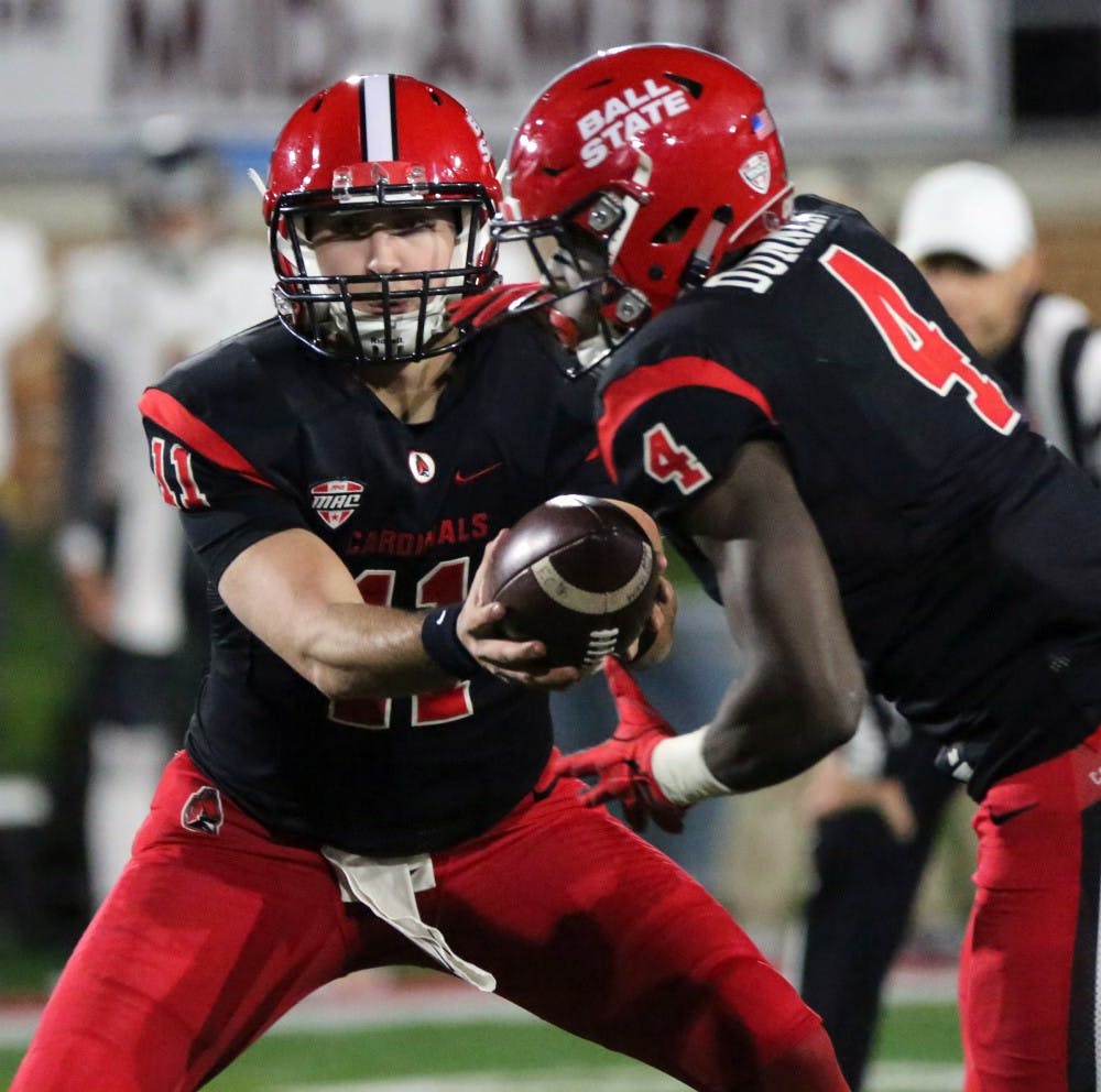 Redshirt freshman quarterback Drew Plitt hands off the ball to sophomore running back Malik Dunner during the Cardinals’ game against Toledo on Oct. 26 at Scheumann Stadium. Ball State lost 58-17. Paige Grider, DN File