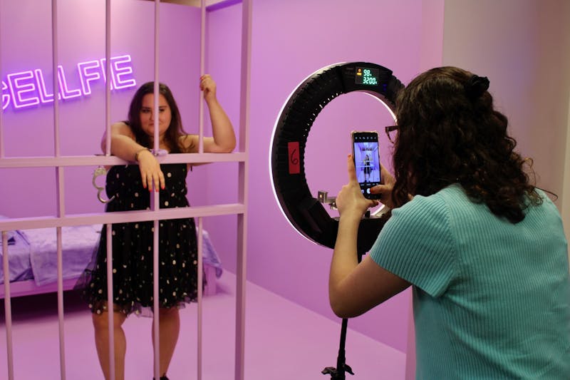 Ball state junior, Elysa Goldberg, takes a photo of Ball State junior Emma Lang in the “cellfie” room at SelfieWRLD Schaumburg, 10/02/21.  Photo by Savannah Jordan