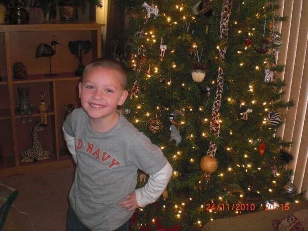 Grayson Joslin poses next to a Christmas tree during the 2010 holiday season. (Grayson Joslin, Photo Provided)