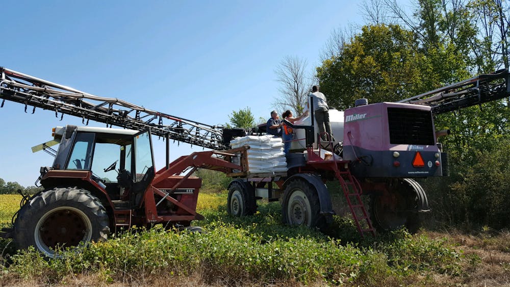 People work on equipment at a farm in Albany, Ind. Jessi Haeft and Emily Placke, Photo Provided