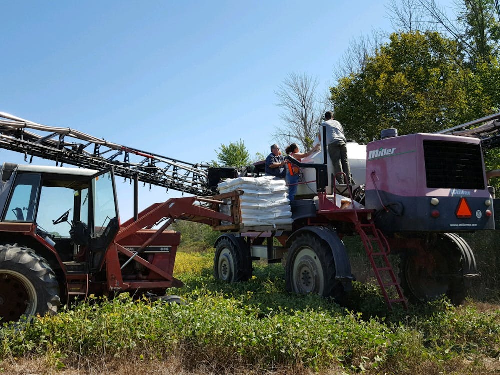 People work on equipment at a farm in Albany, Ind. Jessi Haeft and Emily Placke, Photo Provided