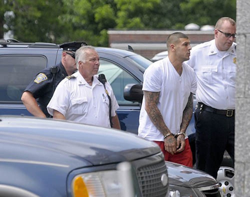 Former New England Patriots tight end Aaron Hernandez is led into the Attleboro district court house to be arraigned on charges in connection with the shooting death of Odin Lloyd, 27, last week. MCT PHOTO