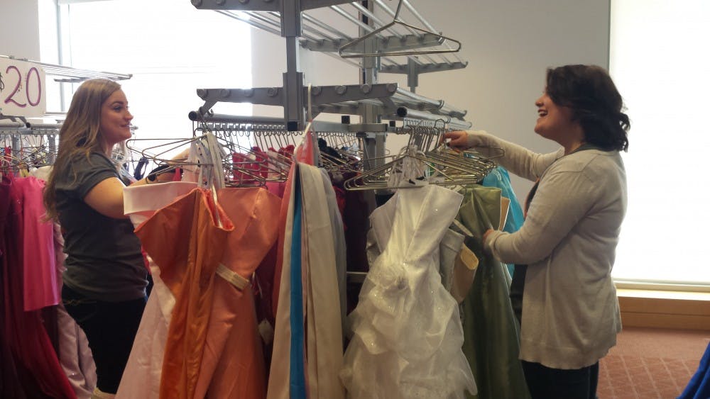 <p>Jillian Hooper and Emily Wade, members of Ball State's Fashion Merchandising Association, browse through dresses donated for FMA's Cinderella's Closet event. The annual event provides discounted prom dresses to high school students. DN PHOTO TRISTAN BENNINGTON</p>