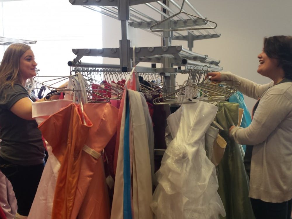 Jillian Hooper and Emily Wade, members of Ball State's Fashion Merchandising Association, browse through dresses donated for FMA's Cinderella's Closet event. The annual event provides discounted prom dresses to high school students. DN PHOTO TRISTAN BENNINGTON