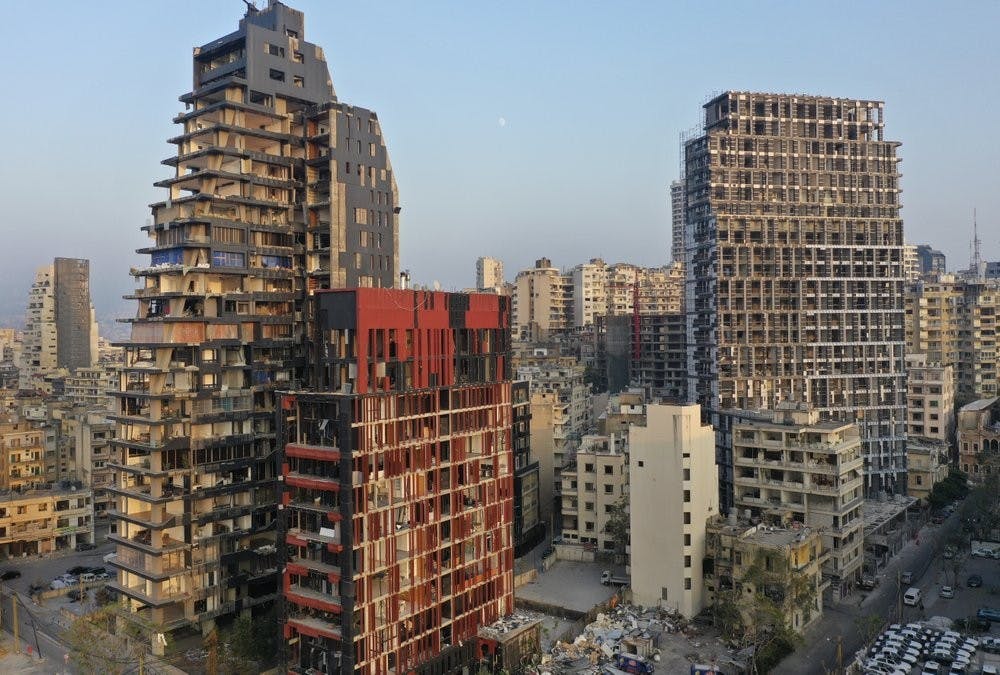 This Aug. 29, 2020 photo shows destroyed buildings near the scene of last month's massive explosion that hit the seaport of Beirut, Lebanon. 
 A month after the giant explosion that killed and injured thousands and destroyed homes across the Lebanese capital, Beirut is still a wounded, grieving city struggling to come to grips with the calamity that struck abruptly on Aug.4. (AP Photo/Hussein Malla)