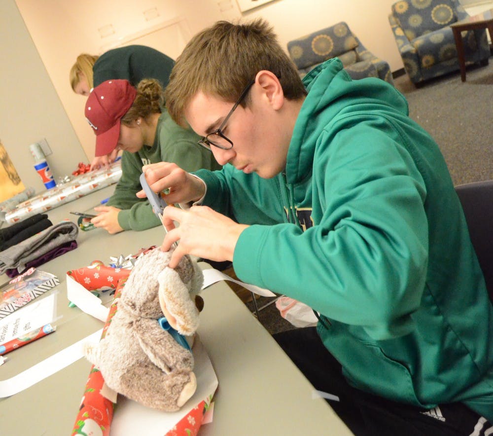 Elementary education major Nicholas Toby wraps a teddy bear during Angel's Tree gift wrapping event Dec. 3, 2018. Toby was one of 85 volunteers who helped wrap gifts. Alyssa Cooper,DN.&nbsp;