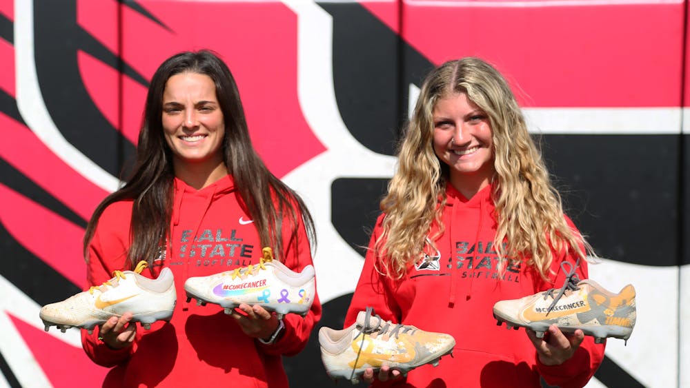 Senior outfielder Hannah Dukeman (left) and Senior pitcher Emma Eubank (right) hold their specially designed cleats for cancer awareness Sept. 18 at First Merchants Ballpark Complex. The softball players are working together to raise money and awarness for pediatric cancer. Mya Cataline, DN