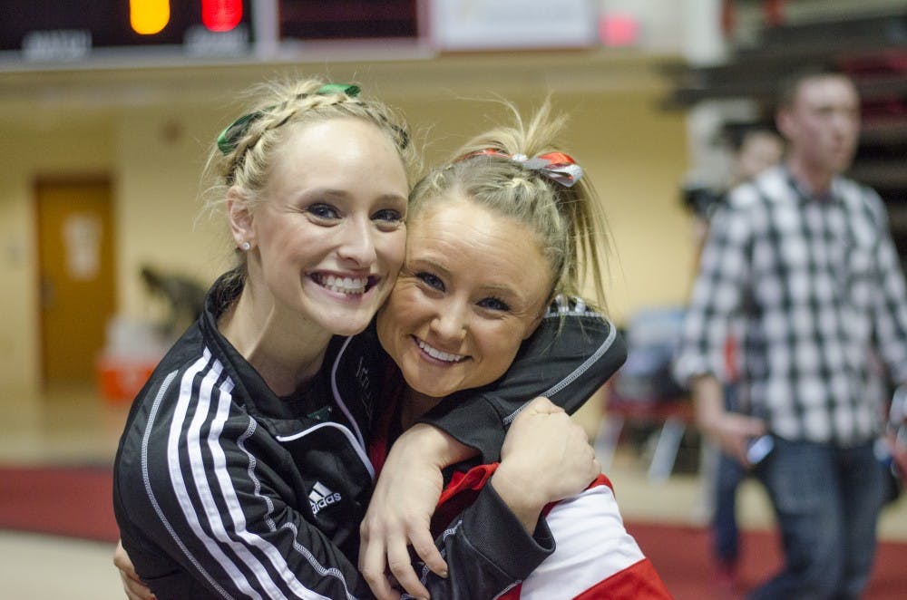 Kimberly and Sarah Ebeyer pose for a photo after the meet against Eastern Michigan and Illinois State on Jan. 24 in Worthen Arena. Kimberly performs for Eastern Michigan, who won the meet. DN PHOTO BREANNA DAUGHERTY