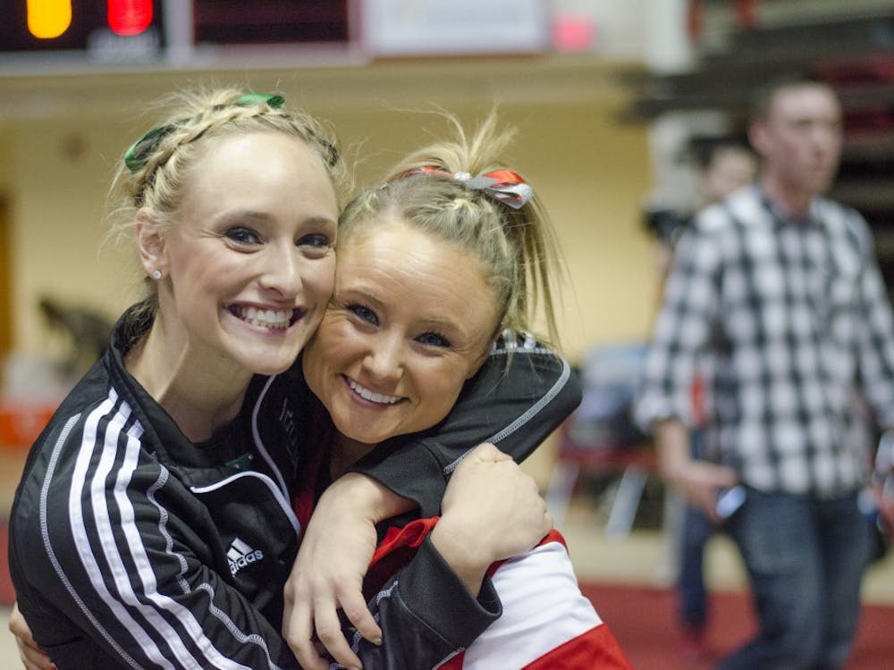 Kimberly and Sarah Ebeyer pose for a photo after the meet against Eastern Michigan and Illinois State on Jan. 24 in Worthen Arena. Kimberly performs for Eastern Michigan, who won the meet. DN PHOTO BREANNA DAUGHERTY