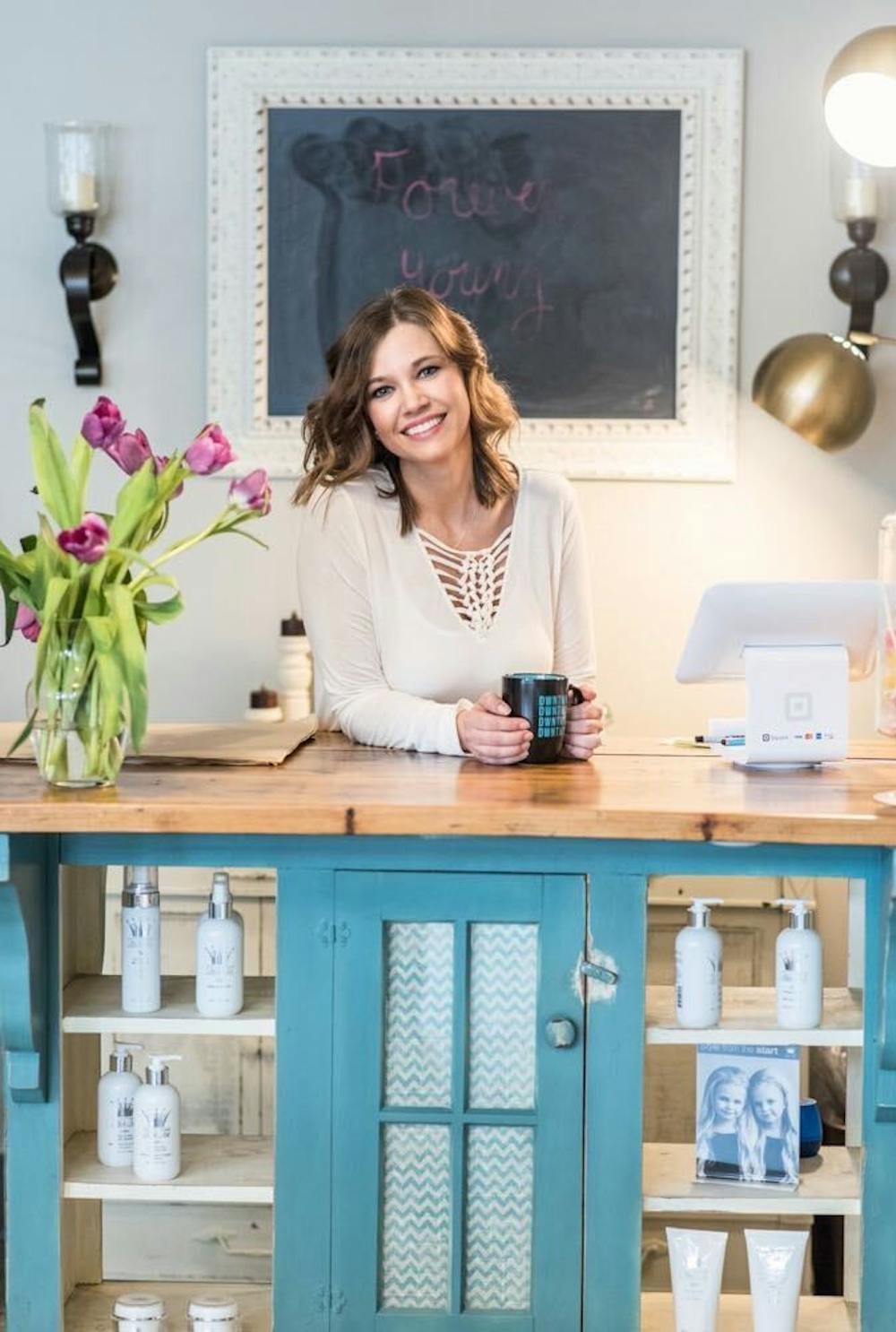 Amanda Hughes, owner of Forever Young, poses at her checkout desk. Hughes had five years of retail experience prior to opening her own boutique. Kishel Photography, Photo Courtesy
