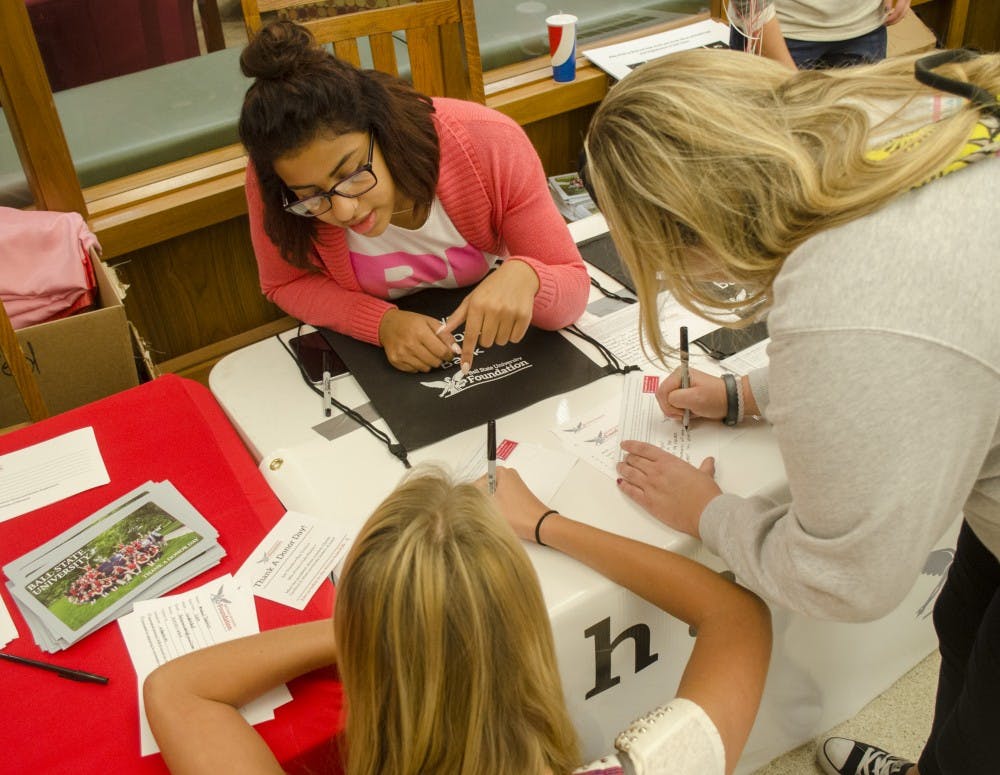 Lauren Pearson, a sophomore public relations major, talks to students about how to fill out a Thank a Donor card during Thank a Donor Day on Nov. 5 in the Atrium. DN PHOTO BREANNA DAUGHERTY