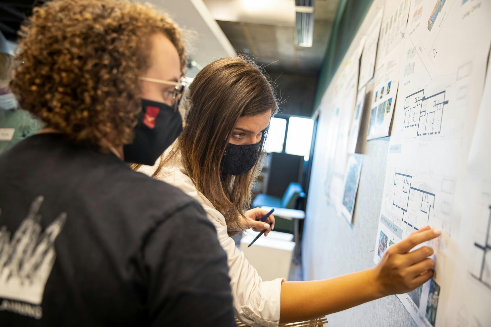 Two College of Architecture and Planning (CAP) students look at a blueprint for a net-zero energy house design idea in the R. Wayne Estopinal CAP building in October 2021. Different classes are focusing on different design elements of the net-zero energy house that is being built for the Solar Decathlon 2023 Build Challenge. Robbie Mehling/ Office of Immersive Learning, Photo Provided