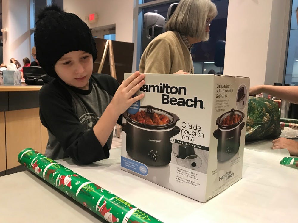 Nine-year-old Ellie Anderson participates in her third year at Secret Families. Anderson was part of the first shift of wrappers, which began wrapping gifts at 7:30 a.m. Anderson said she was excited to help give presents to those who don’t have as much as her.&nbsp;Hannah Gunnell, DN