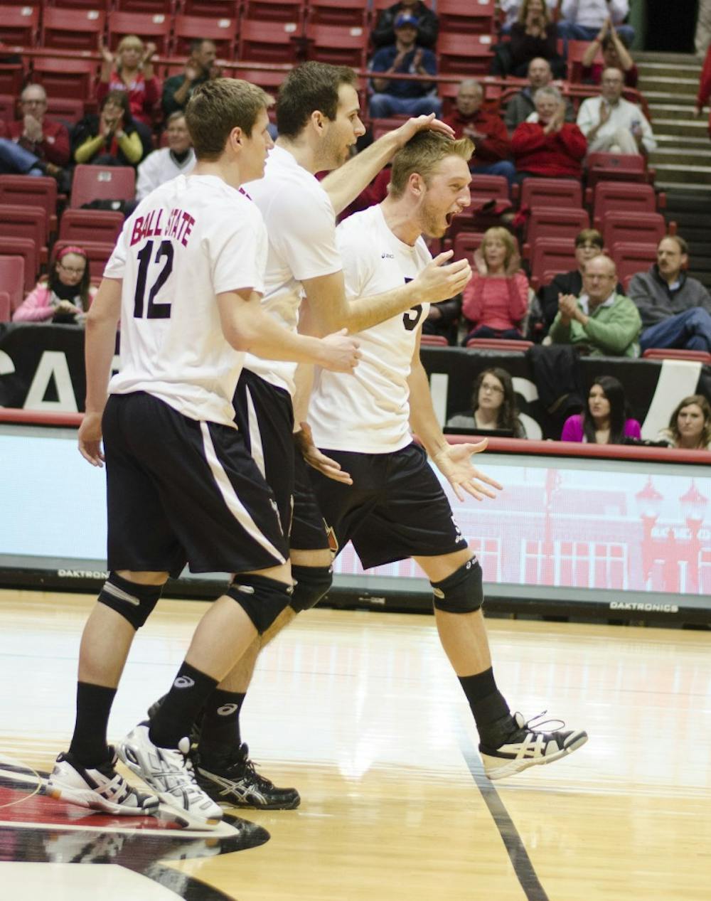 Senior outside attacker Matt Sutherland, senior middle attacker Matt Leske and senior setting Graham McIlvaine celebrate after getting a point in the first set against Mount Olive on March 1 at Worthen Arena. DN PHOTO BREANNA DAUGHERTY 