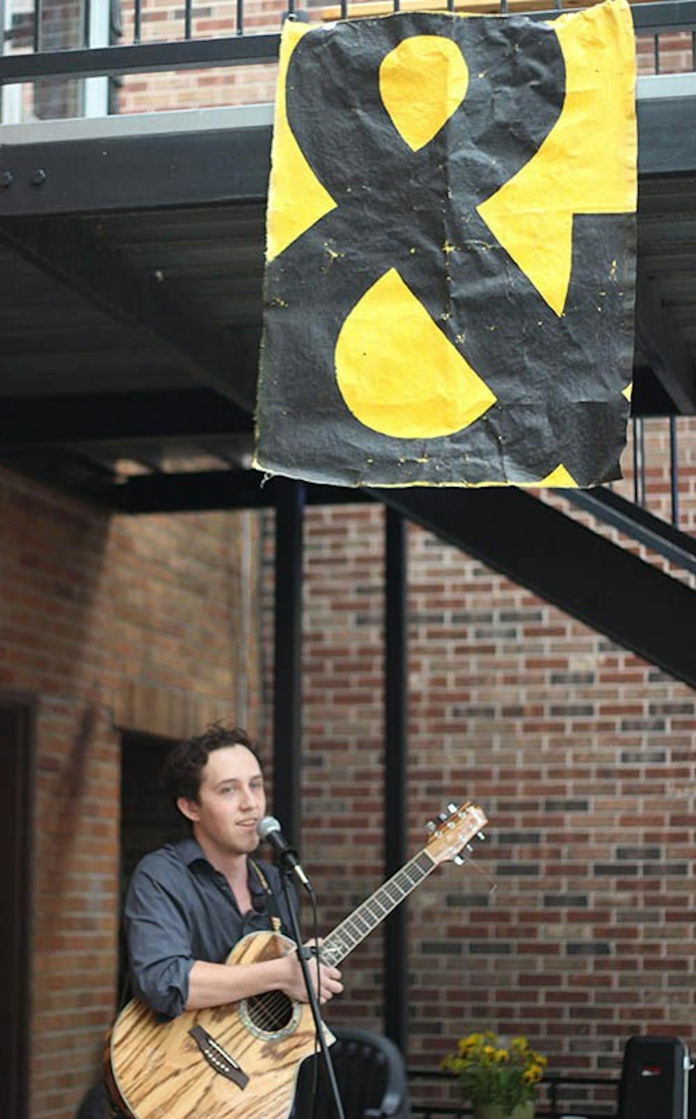 Phil Tislow sings at the Cup during the free art show hosted by Glue and Scissors Society. The event showcases community produced artwork that will remain hanging in the cup during the month of June.  DN PHOTO KRYSTAL BYERS 