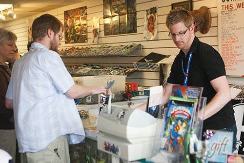 Jason Pierce, owner of Alter Ego Comics in Muncie, checks out a customer on May 4, also known as Free Comic Book Day. Pierce has been in business for eight and half years now, and he said the event is his busiest day of the year. DN PHOTO JORDAN HUFFER