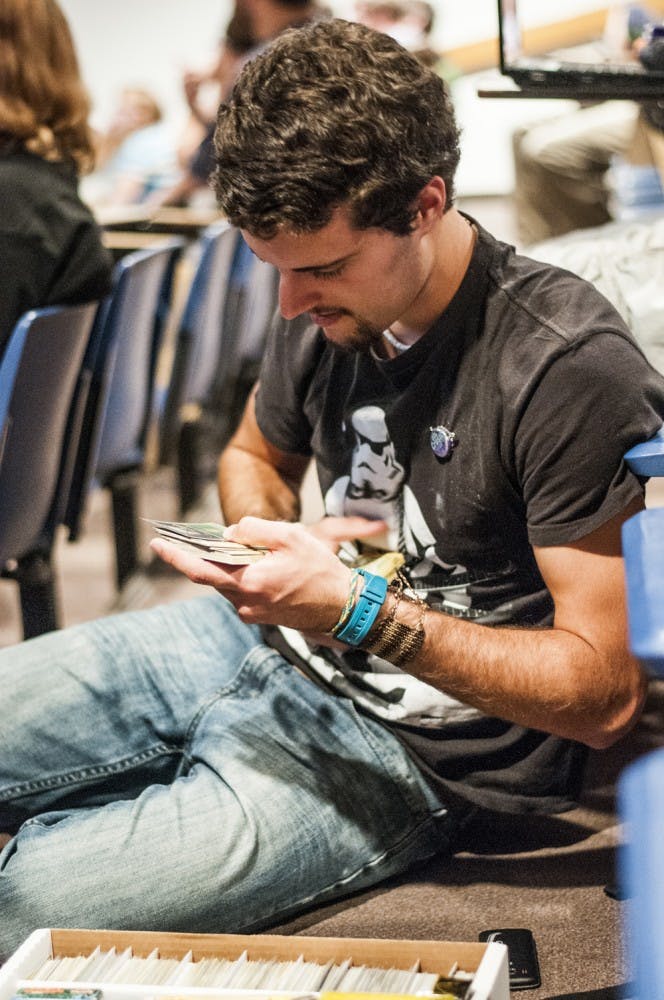 Freshman English education major Joel Summer looks through cards during a meeting of the Pokémon Trainer’s Union on Oct. 10. The club gathers together students interested in Pokémon in any capacity. DN PHOTO JONATHAN MIKSANEK