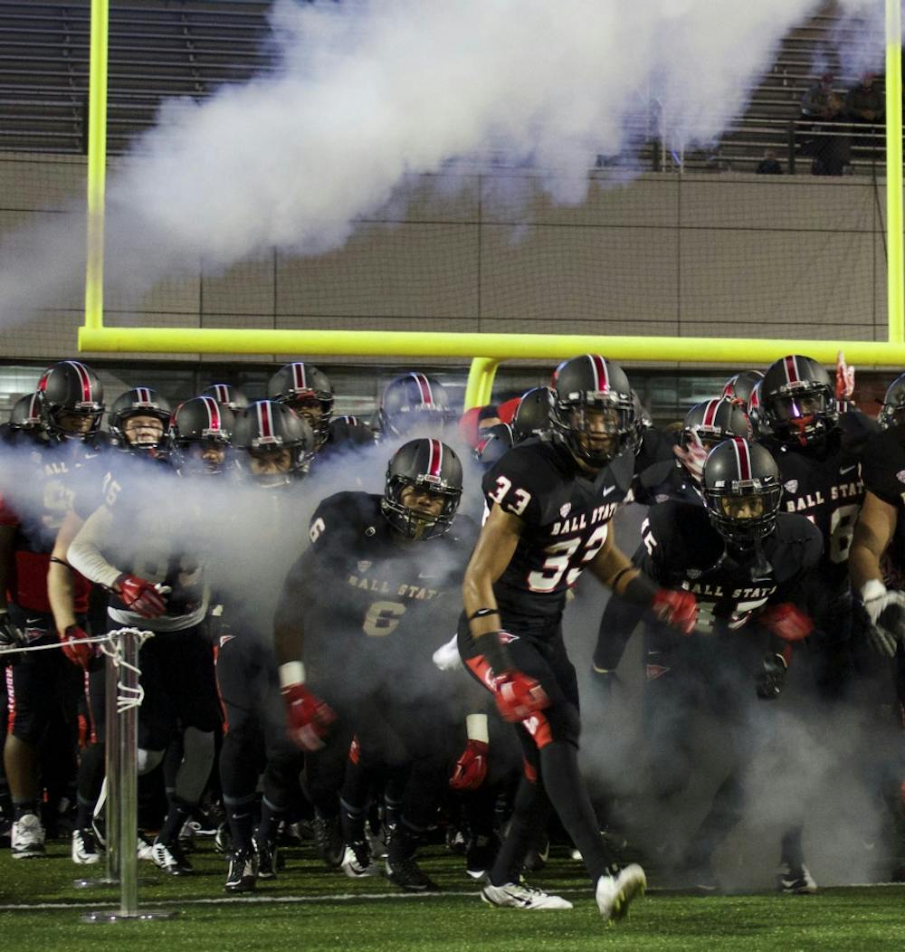 The Ball State Cardinals enter the field through a cloud of smoke at the beginning of the game against Bowling Green on Nov. 24 at Scheumann Stadium. DN PHOTO GRACE RAMEY