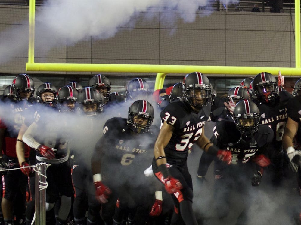 The Ball State Cardinals enter the field through a cloud of smoke at the beginning of the game against Bowling Green on Nov. 24 at Scheumann Stadium. DN PHOTO GRACE RAMEY