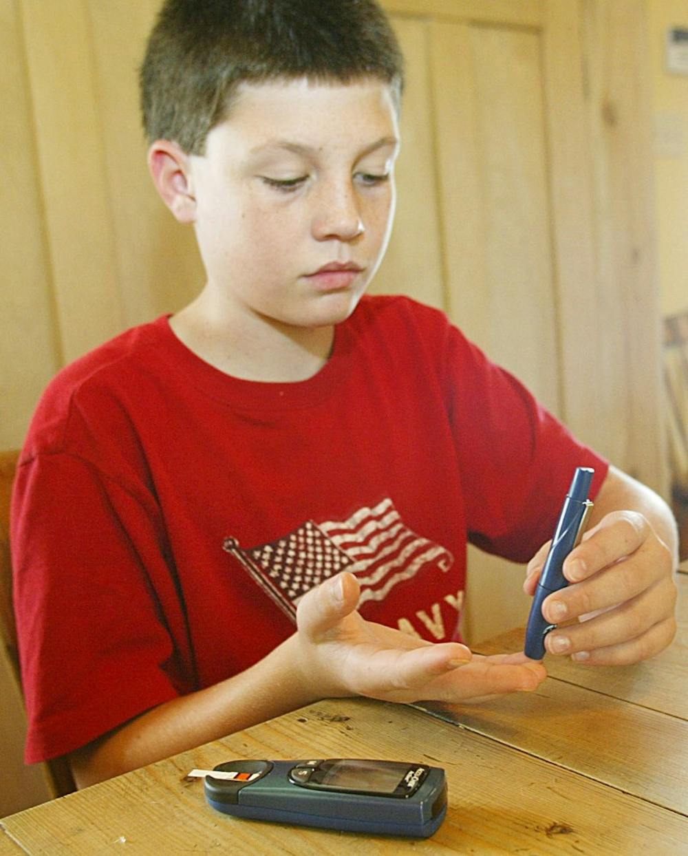 KRT SOUTH STORY SLUGGED: HEALTH-GA-YOUTHDIABETES KRT PHOTOGRAPH BY G. MARC BENAVIDEZ/COLUMBUS LEDGER-ENQUIRER (October 21) Bryan Wells, 12, a Type One diabetic, sticks himself on the finger to draw blood to test his blood glucose level at his Buena Vista, Georgia, home, on September 24, 2003. (nk) 2003 (Diversity)