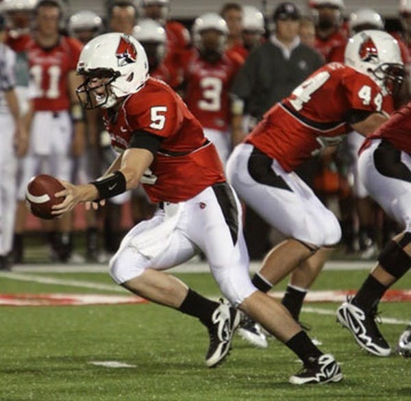 Ball State University quarterback, Kelly Page, hands off the ball during his first start for the Cardinals. Page threw 15 completions for 140 yards. DN PHOTO/ALEX HUTCHISON