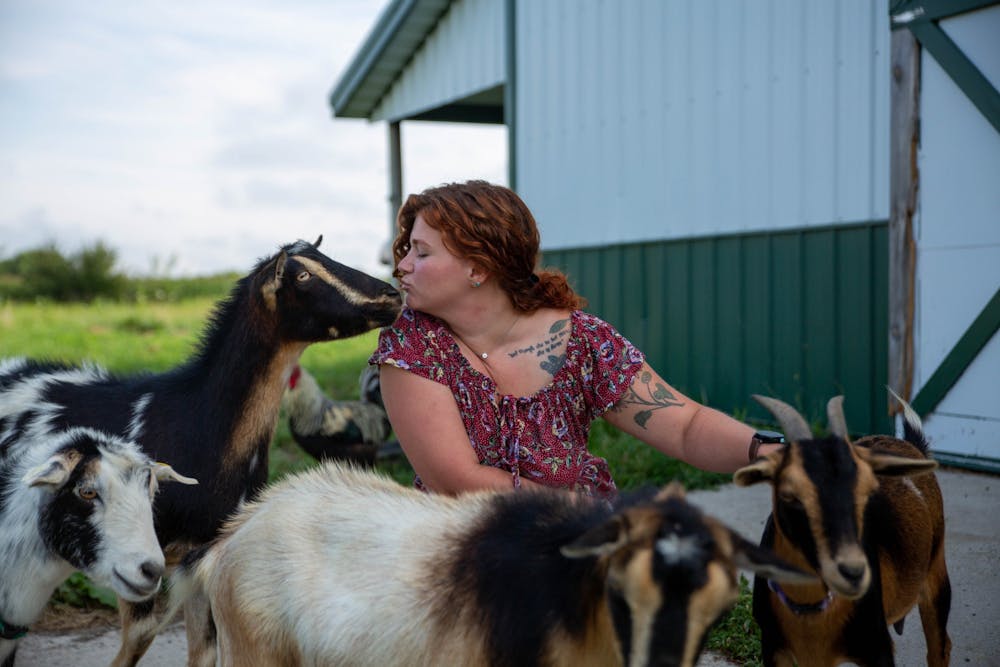 Erica Markley gives a kiss to Barnaby on her farm in Gaston, Indiana, Aug. 18, 2021. Aside from being a farmer, Markley paints landscapes on miniature canvases that she sells on her Etsy page. Sumayyah Muhammad, DN 