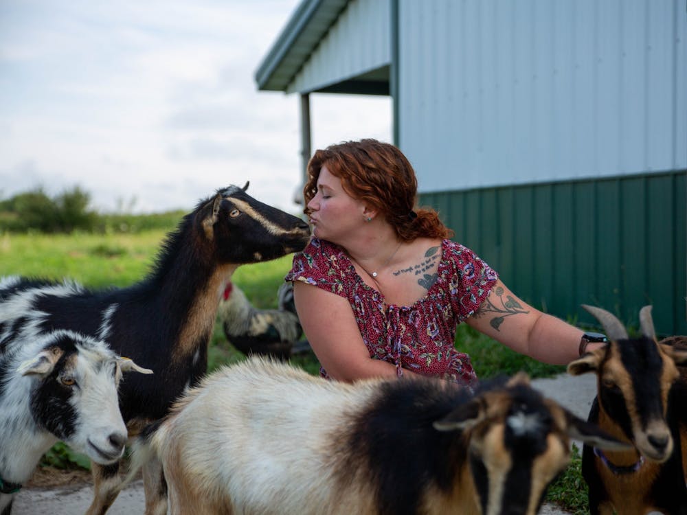 Erica Markley gives a kiss to Barnaby on her farm in Gaston, Indiana, Aug. 18, 2021. Aside from being a farmer, Markley paints landscapes on miniature canvases that she sells on her Etsy page. Sumayyah Muhammad, DN