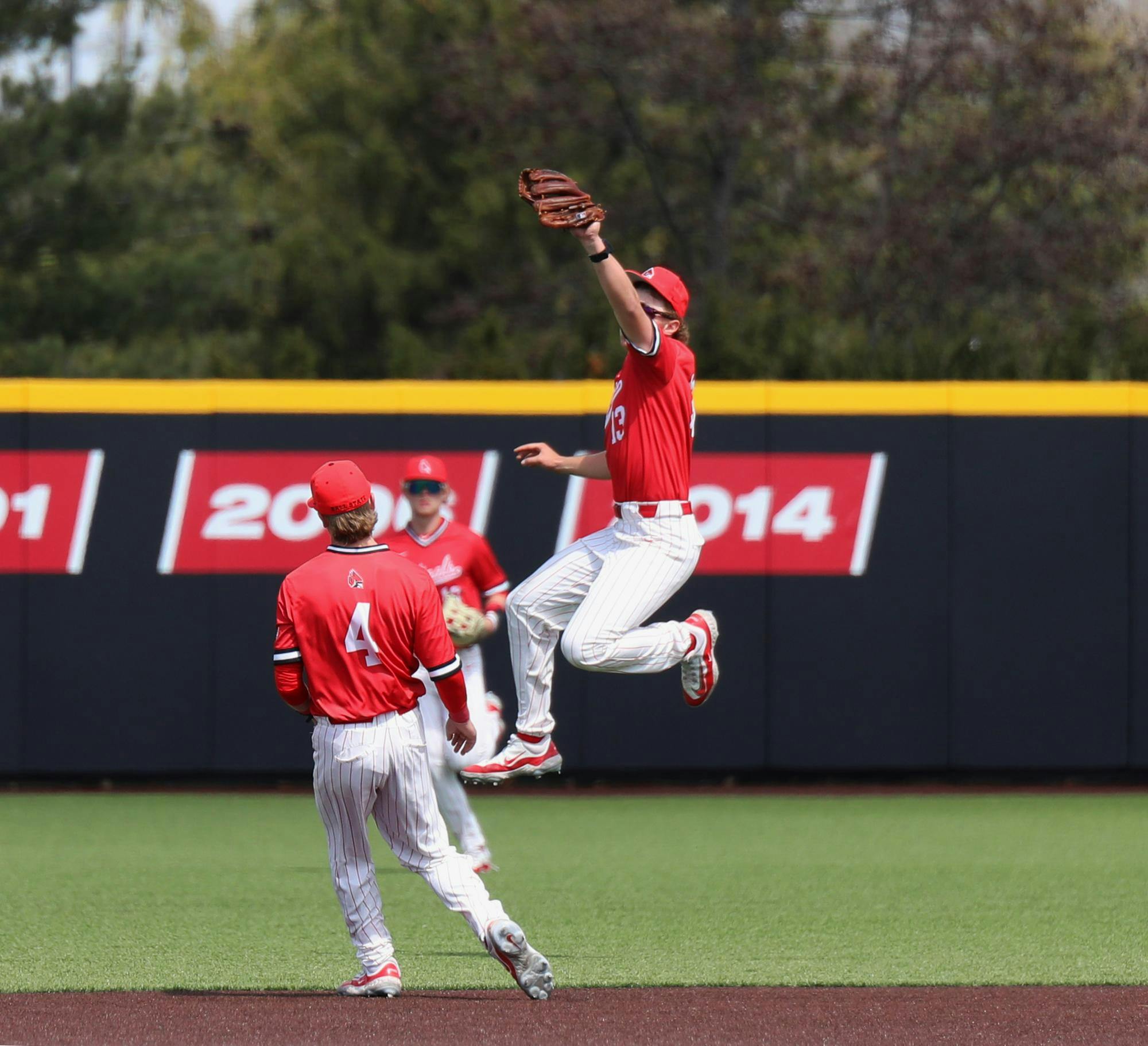 Junior infielder Nick Husovsky jumps to catch a ball hit by Ohio March 30 at First Merchants Ballpark Complex. The Cardinals won 14-7 against the Bobcats. Mya Cataline, DN