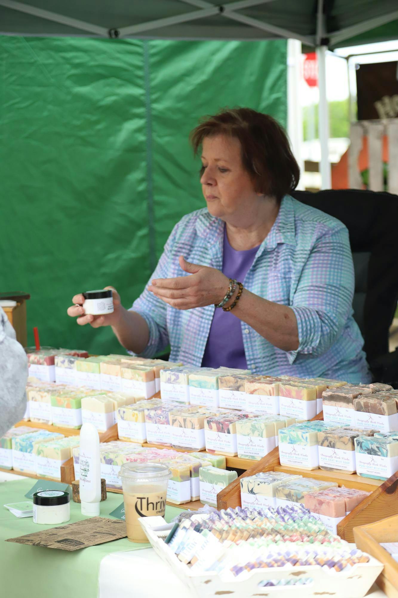 A vendor from Dragonfly Bath Works shows off her product to customers June 8 at the Minnetrista Museum and Gardens farmers market. The event takes place every weekend. Olivia Ground, DN