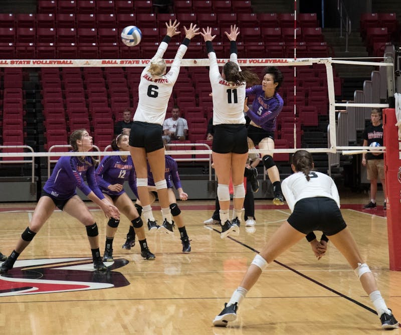 (Left) Redshirt junior middle hitter Avery Devoe and Sophomore setter Amber Seaman block the ball at the game against Evansville on Sept.14 at John E. Worthen Arena. The Cardinals had six blocks throughout the game. Emily Coats, DN File