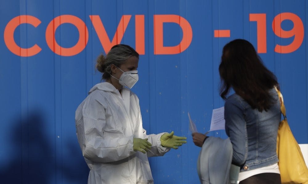 A woman talks to a healthcare worker before getting tested for COVID-19 at a sampling station in Prague, Czech Republic, Monday, Sept. 21, 2020. The country coped well with the first wave of the coronavirus infections in the spring but has been facing a record surge of the new confirmed cases last week. (AP Photo/Petr David Josek)
