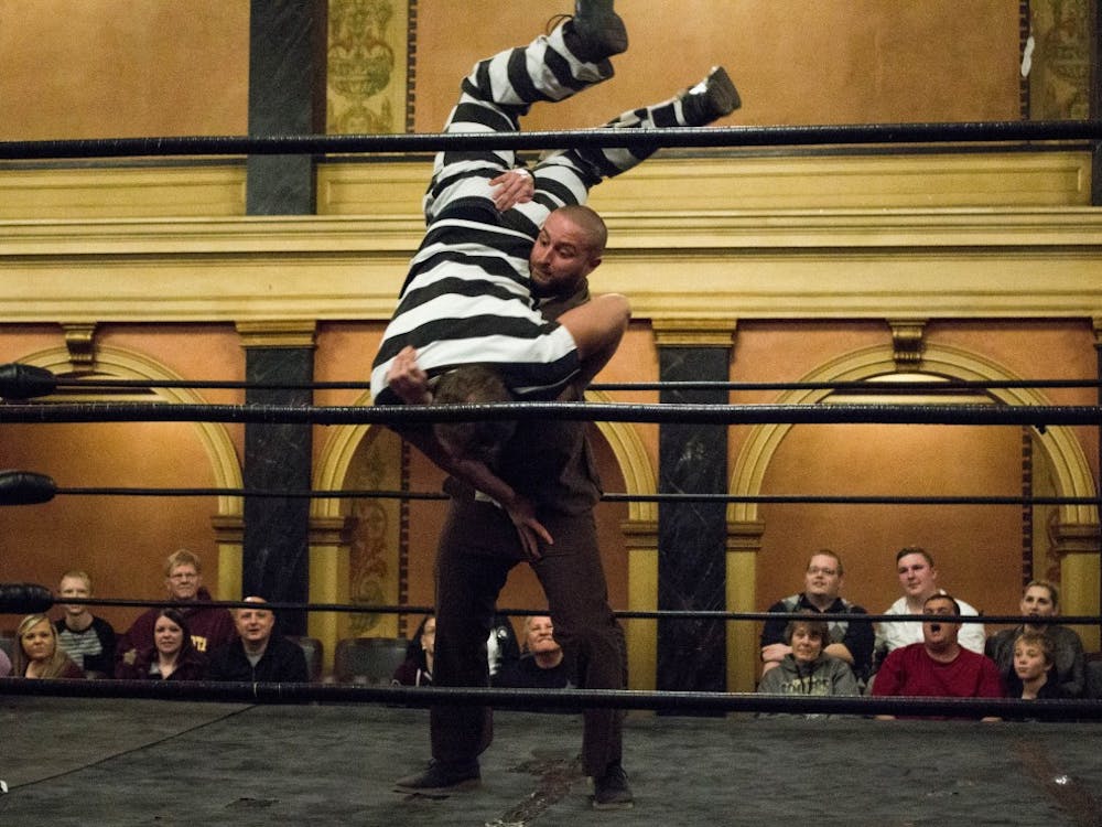 Wrestling character Rep. Gavin Q. Volstead punishes a criminal character with 10 bodyslams during Olde Wrestling's Indiana debut event, A Bonanza of Bodyslams, at Cornerstone Center for the Arts on Nov. 19. The event, which celebrates vintage-style wrestling, aimed to get 50 bodyslams by the end of the night. Grace Ramey // DN
