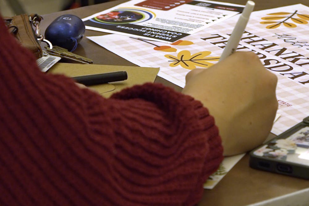 A Ball State student writes a thankful letter at Ball State’s Thankful Thursday event at the Atrium. 
