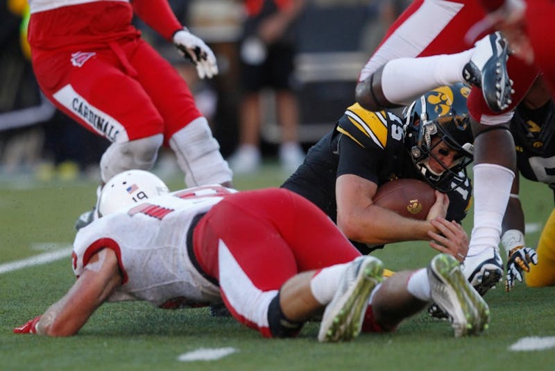 Iowa quarterback Jake Rudock protects the ball after being tackled on Sept. 6 in Kinnick Stadium. Rudock ran for 46 yards on seven carries on the game. Iowa defeated Ball State, 17-13. (The Daily Iowan/Rachael Westergard)