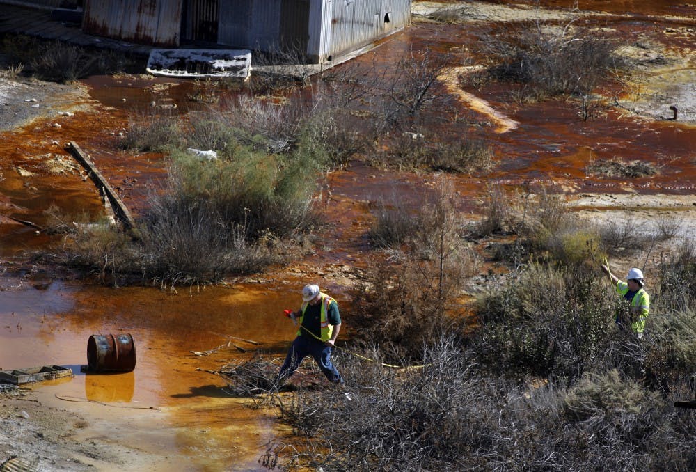 Hazardous waste crews, working with the EPA, measure the area of the upper pond that has turned orange from rust and contains mercury and sulfuric acid as seen at the deserted New Idria mercury mines, October 25, 2011. The mines, in rural San Benito County, were once a bustling community, but now the miners are gone, and the pollution remains. (Karen T. Borchers/San Jose Mercury News/MCT)