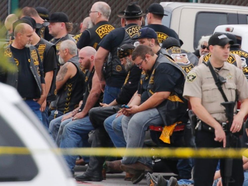 A McLennan County deputy stands guard near a group of bikers in the parking lot of a Twin Peaks restaurant Sunday, May 17, 2015, in Waco, Texas. Photo by The Associated Press
