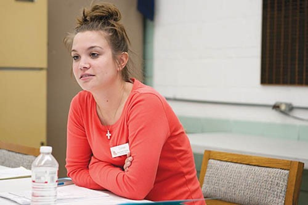 Carissa Harrington, a senior social work major, speaks about the importance of helping the elderly at the Senior Center in Muncie. Harrington is one of several people who were helping sign people up for the new food program that aims to get food into the hands of people who may not able able to afford it. DN PHOTO JORDAN HUFFER