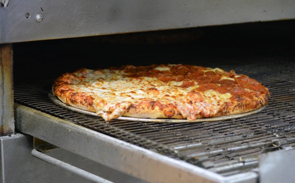 A finished pizza travels out of the oven at Cousin Vinny's in Muncie, Indiana. DN PHOTO JACOB COLLIER
