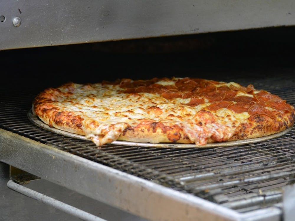 A finished pizza travels out of the oven at Cousin Vinny's in Muncie, Indiana. DN PHOTO JACOB COLLIER