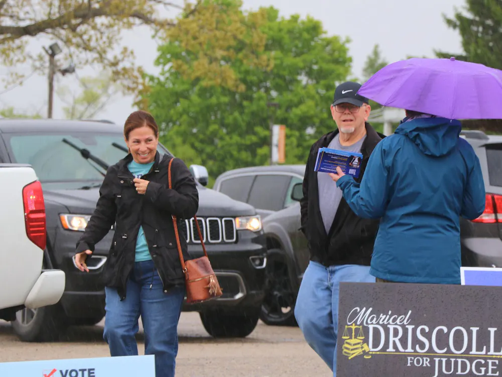 Residents walking past a candidate into a voting center on Election Day. Cameron Noe, DN.