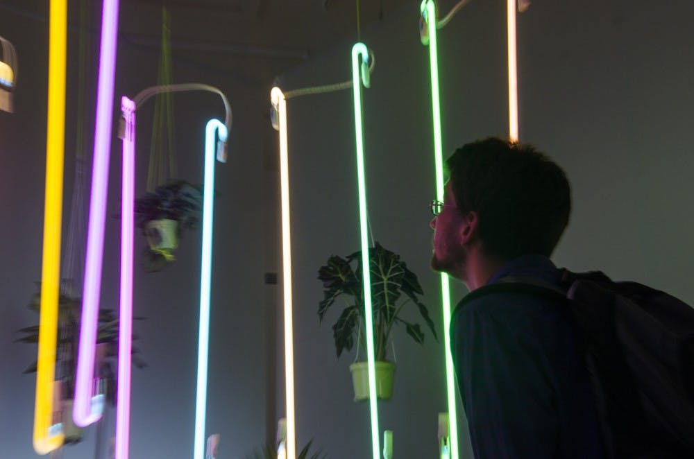 Dylan Hayers, a senior natural resources major , looks at "Ultraviolet" by Hiromi Takizawa. Takizawa uses her cultural background for her artwork. DN PHOTO BREANNA DAUGHERTY 