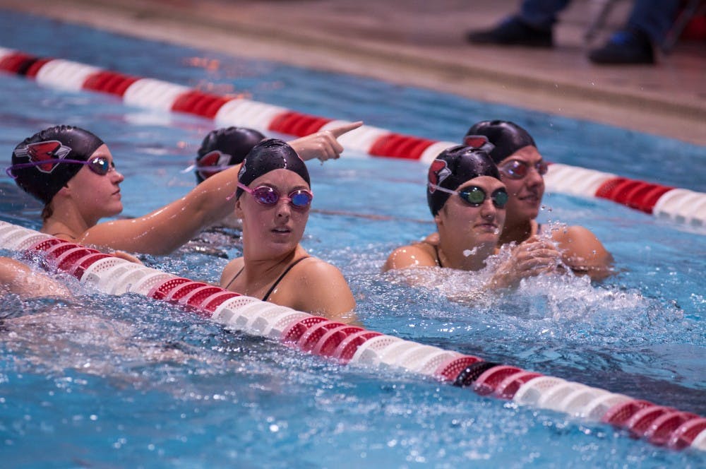 A group of Ball State swimmers talk in one of the lanes during a break at the 10th annual Doug Coers Invitational at Lewellen Aquatic Center. DN PHOTO KATIE GRAY