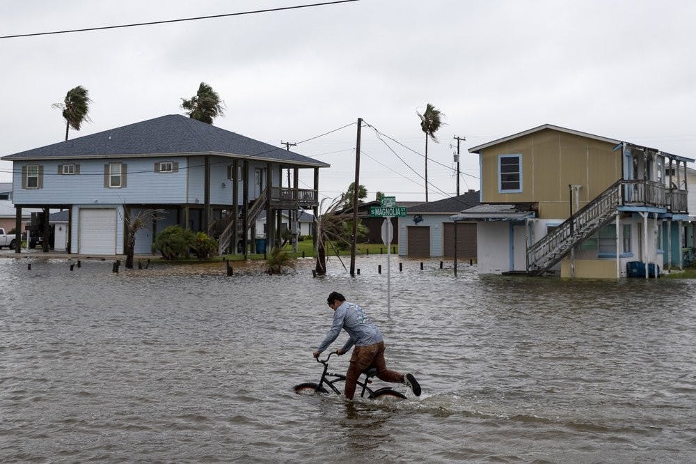 A boy rides his bike down South Magnolia Street in Rockport, Texas, as Tropical Storm Beta approaches on Monday, Sept. 21, 2020. (Courtney Sacco/Corpus Christi Caller-Times via AP)