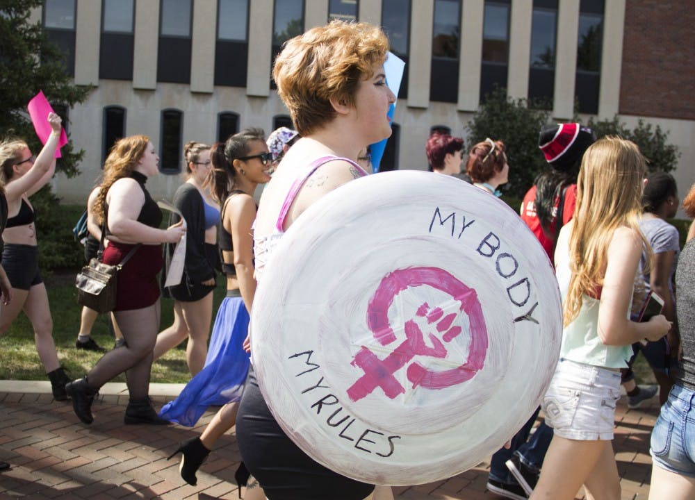 Emma Engler walks down McKinley Avenue to participate in Feminists For Action's Slutwalk. This Slutwalk was the club's third time hosting the event. DN PHOTO EMMA ROGERS