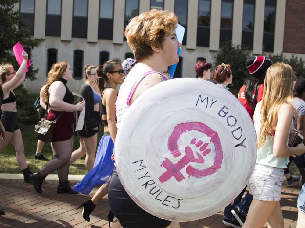 Emma Engler walks down McKinley Avenue to participate in Feminists For Action's Slutwalk. This Slutwalk was the club's third time hosting the event. DN PHOTO EMMA ROGERS