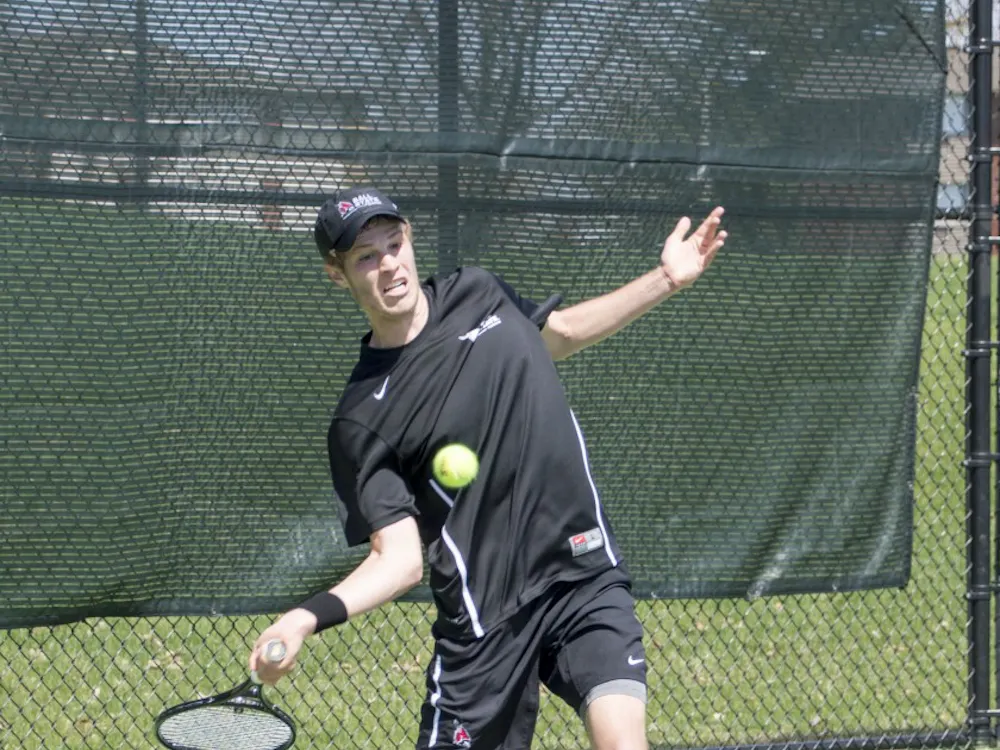 Sophomore Lucas Anderson hits the ball during the match against Western Michigan on April 11 at Cardinal Creek Tennis Courts. DN PHOTO ALAINA JAYE HALSEY