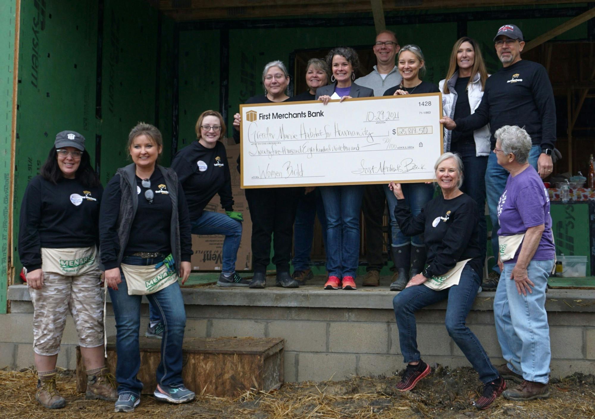 Volunteers at 713 E. Willard St. pose with a donation check on the porch in front of the property. After the women of First Merchants Bank raised nearly $6,000 for the Greater Muncie Habitat for Humanity’s women’s build, the bank’s general manager donated an additional $20,000 toward the build. Taylor Smith, DN